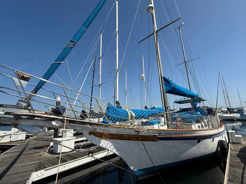 Sailboat Vagabond 47, 1986 model, docked at marina under clear blue sky.