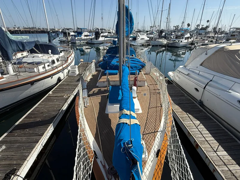 Sailboat Vagabond 47, 1986 model, docked in a marina with other boats.