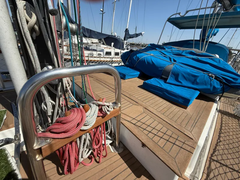 Deck of 1986 Vagabond 47 sailboat with ropes and blue covers.