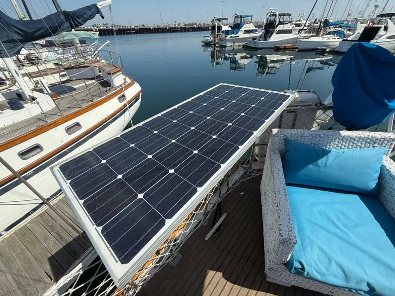 Solar panel on 1986 Vagabond 47 yacht with blue cushioned seating, docked at marina.