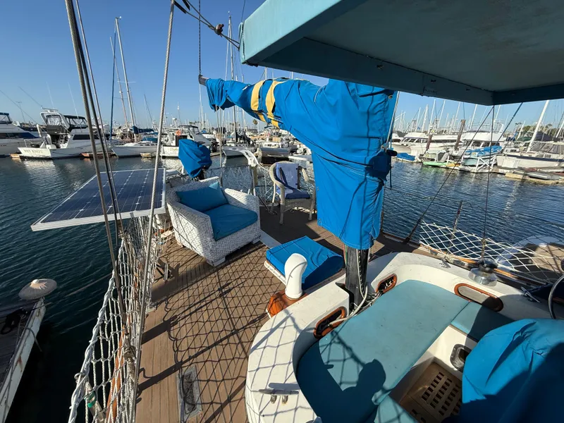 1986 Vagabond 47 sailboat deck with blue covers and solar panels in a marina.