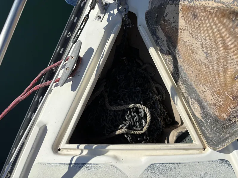 Anchor chain storage on 1985 Newport 30 sailboat, featuring ropes and deck details.