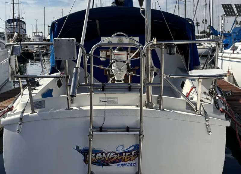 1985 Newport 30 sailboat docked, rear view with stainless steel railings and ladder.