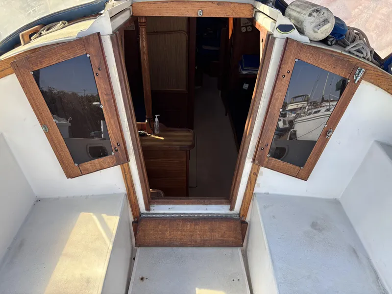 Cockpit view of a 1985 Newport 30 sailboat with wooden cabin doors.