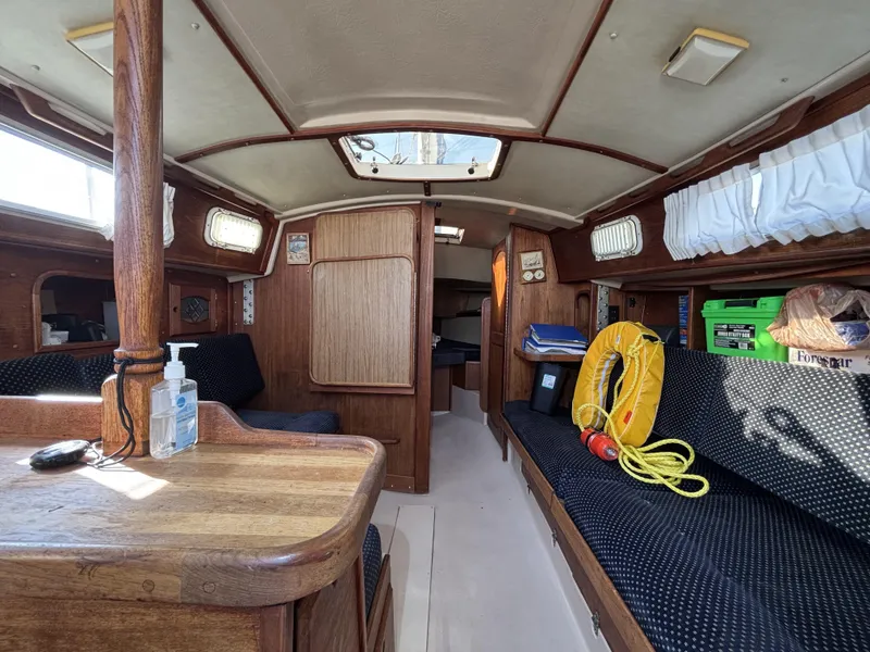 Interior of a 1985 Newport 30 sailboat, featuring wood finishes and nautical equipment.
