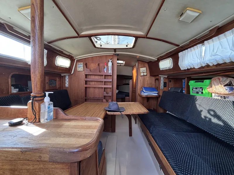 Interior of a 1985 Newport 30 sailboat with wooden furnishings and seating area.