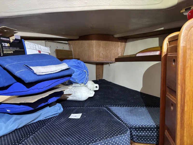 Interior cabin of a 1985 Newport 30 sailboat with cushions and storage.