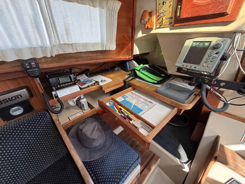Navigation station inside a 1985 Newport 30 sailboat, featuring equipment and storage drawers.