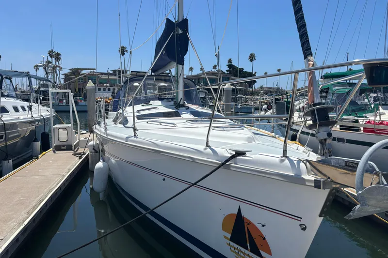 Sailboat docked at marina, 1999 Hunter 410 model, sunny day, calm waters.