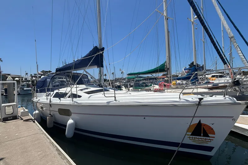 Sailboat docked at marina, 1999 Hunter 410 model, clear blue sky.