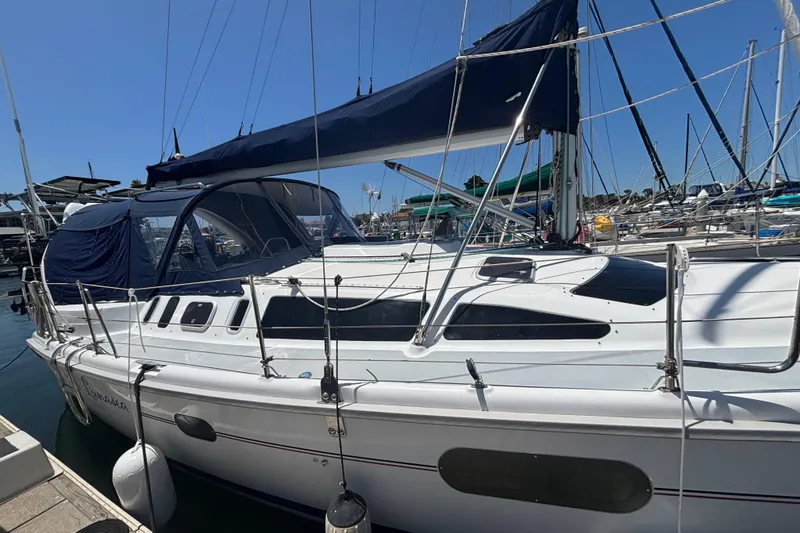 Sailboat Hunter 410, 1999 model, docked at marina with blue canopy.