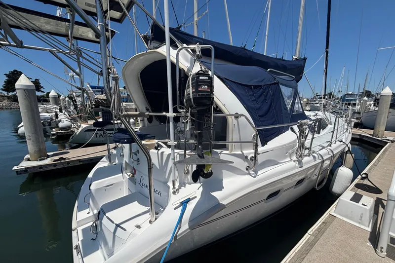 Sailboat docked at marina, 1999 Hunter 410 model with blue canopy.
