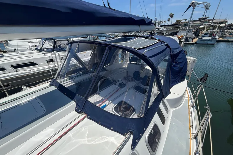 1999 Hunter 410 sailboat with blue canopy docked at marina.