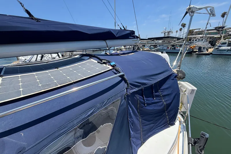 Sailboat with blue canopy and solar panels, Hunter 410 model, docked in marina, 1999.