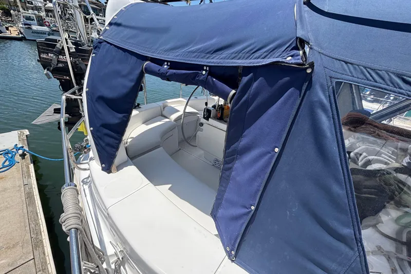 1999 Hunter 410 sailboat with blue canopy docked at marina.