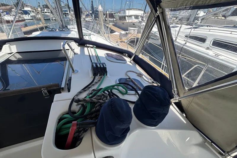 Cockpit of a 1999 Hunter 410 sailboat with ropes and marina view.