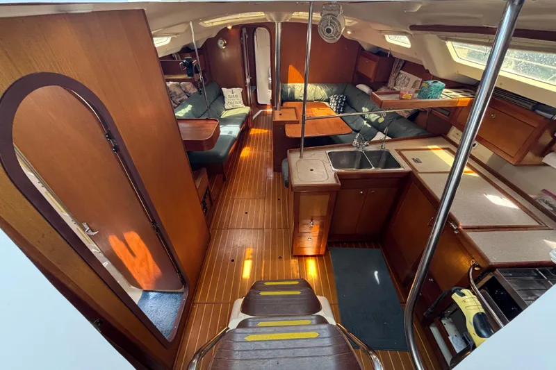 Interior of 1999 Hunter 410 sailboat with wood finish and cozy seating area.