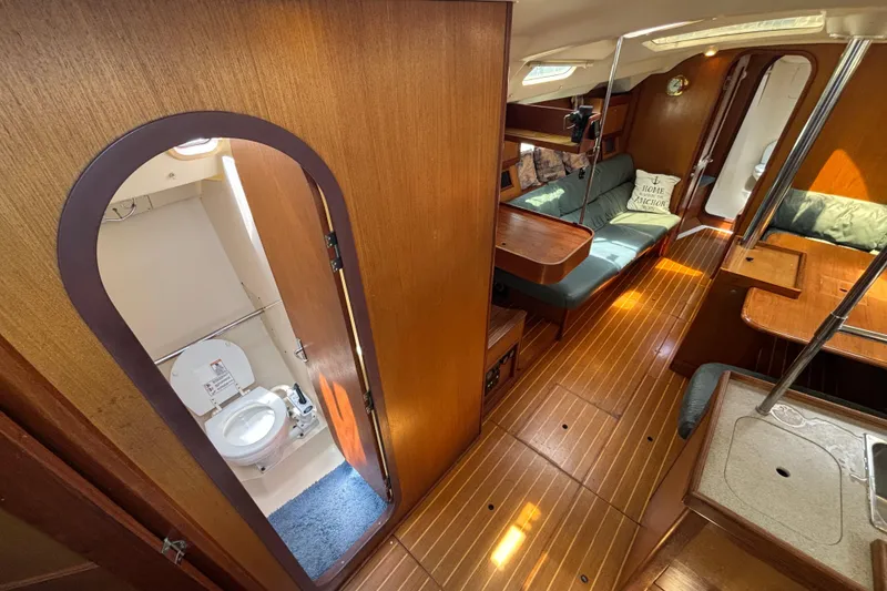 Interior of a 1999 Hunter 410 sailboat featuring a cozy cabin and compact bathroom.