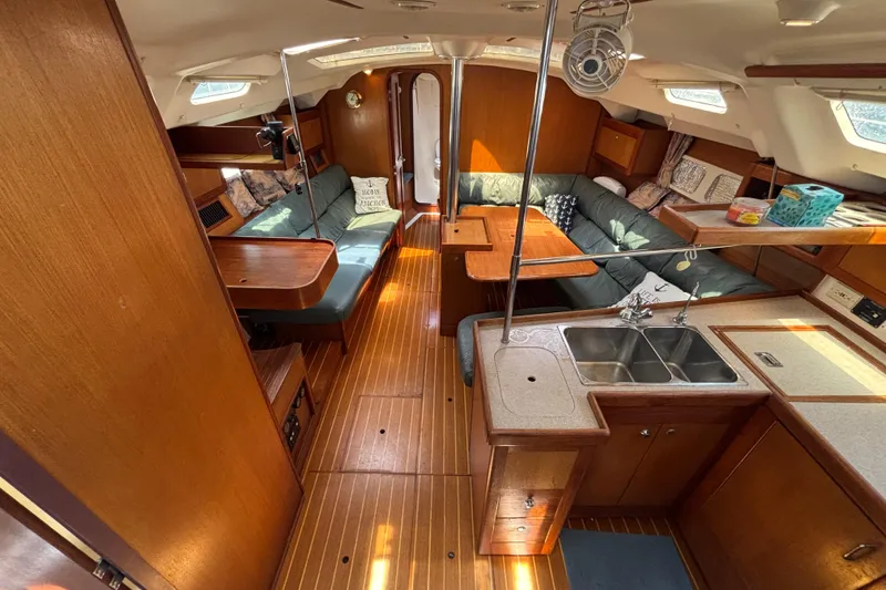 Interior of a 1999 Hunter 410 sailboat with wood finish and cozy seating area.
