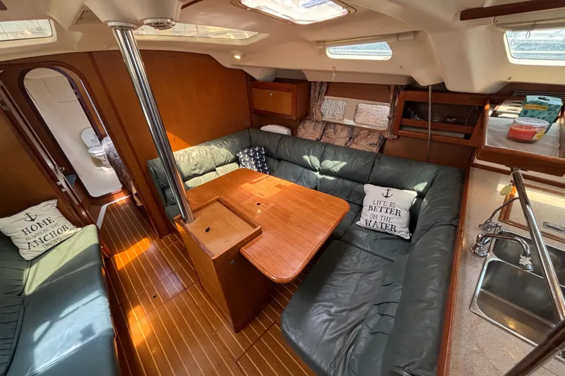 Interior of 1999 Hunter 410 sailboat with cozy seating and wooden table.