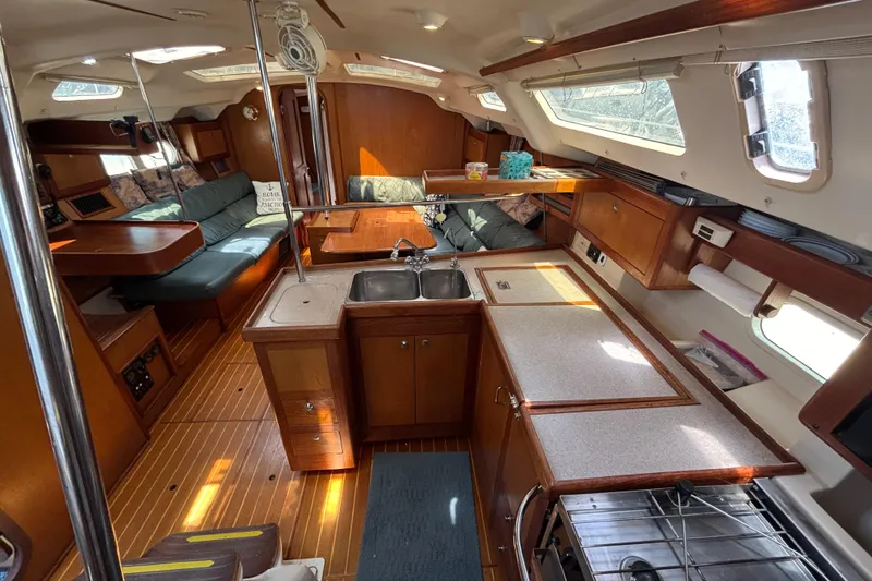 Interior of a 1999 Hunter 410 sailboat with wood finishes and cozy seating area.