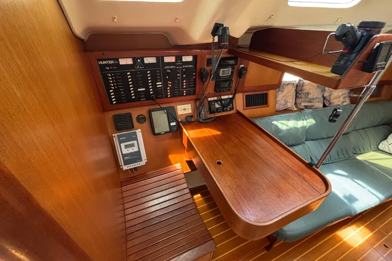 Navigation station of 1999 Hunter 410 sailboat with control panels and seating area.