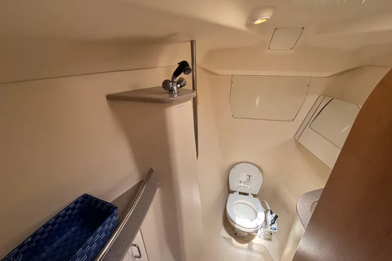 Compact bathroom in a 1999 Hunter 410 yacht, featuring a toilet and sink.
