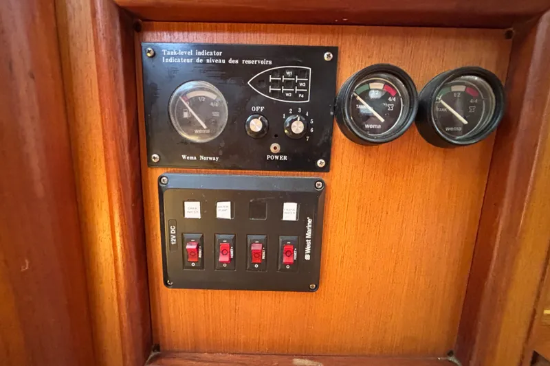 Control panel of a 1999 Hunter 410 boat with gauges and switches.