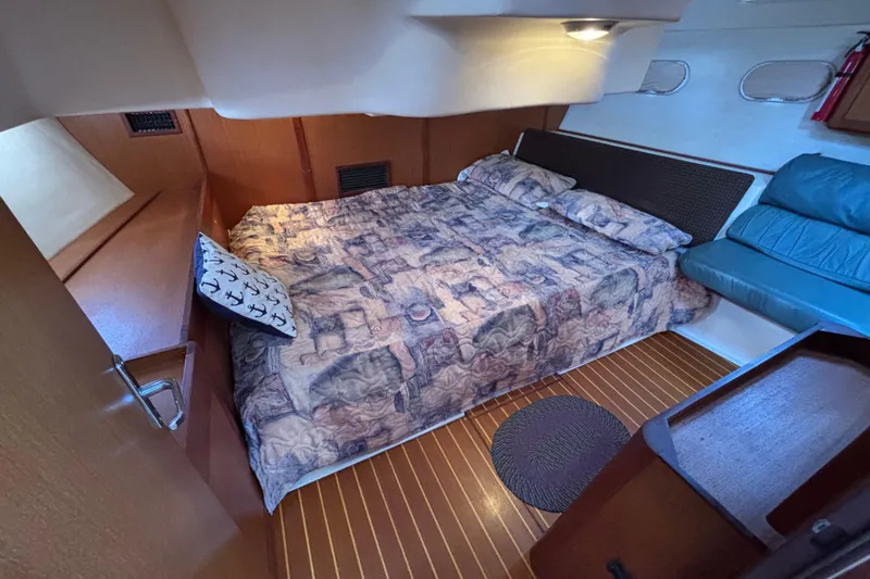 Cozy cabin interior of 1999 Hunter 410 sailboat with bed and seating area.