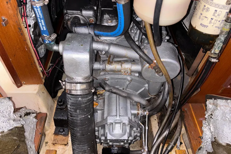 Engine compartment of a 1999 Hunter 410 sailboat, showing mechanical components and hoses.