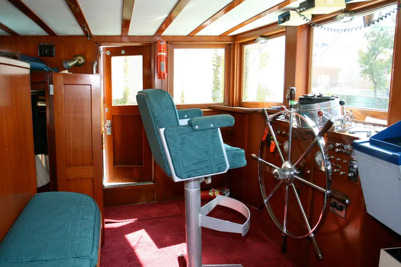 Interior of a classic yacht with steering wheel and seat, built in 1946.