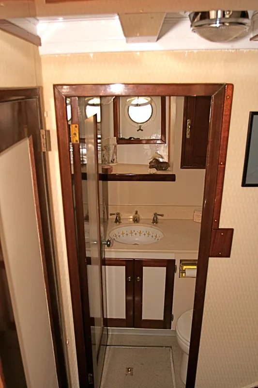 Interior of classic yacht with wood paneling and porthole.