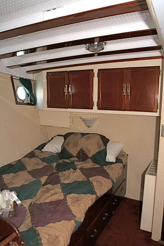 Bedroom on a 1946 classic yacht with wooden cabinets.