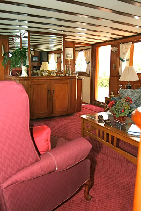 Interior of a classic yacht with red carpet and wooden furniture, built in 1946.