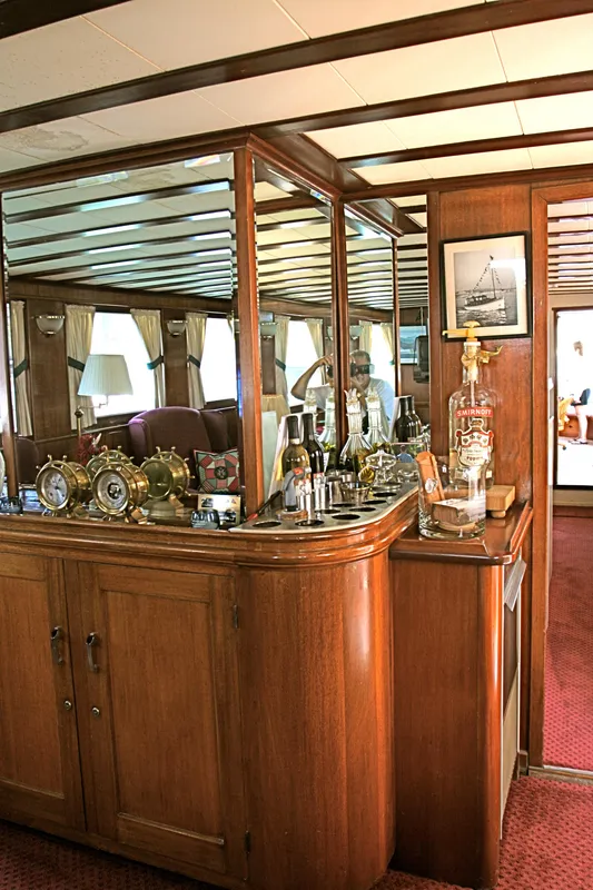 Interior of classic yacht with wooden furnishings and nautical decor.