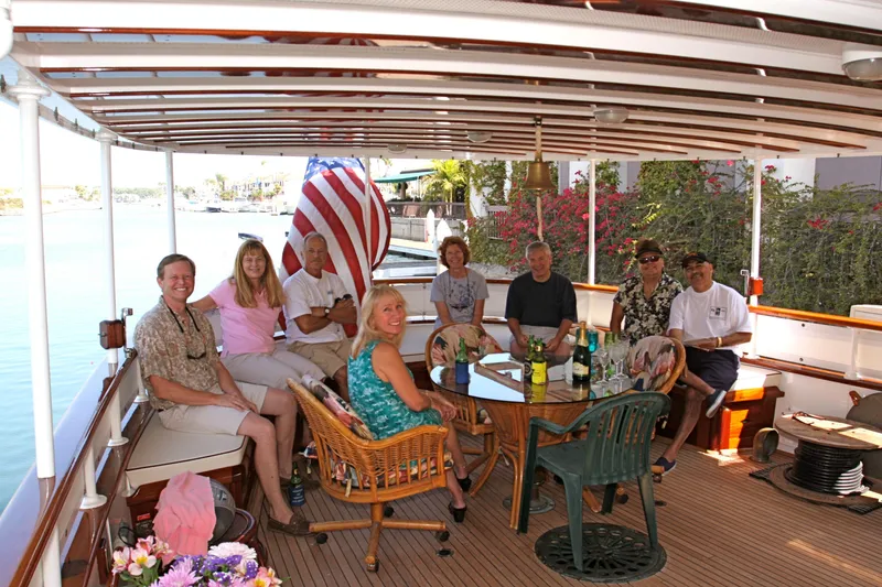 Group of people relaxing on a 1946 classic yacht, enjoying the day.