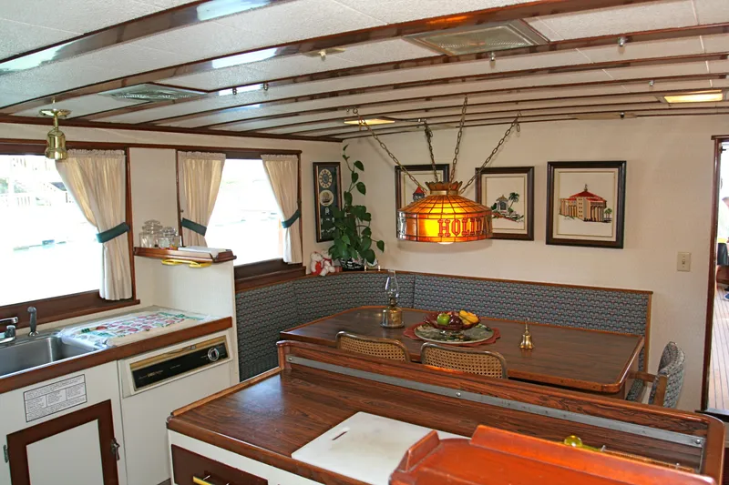 Interior of classic yacht with wooden furnishings and nautical decor.