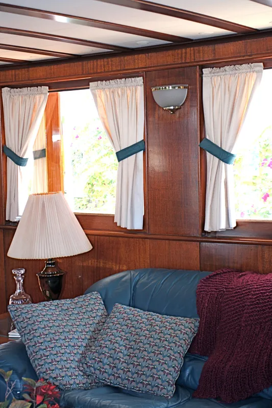 Interior of classic yacht with wood paneling and blue accents.