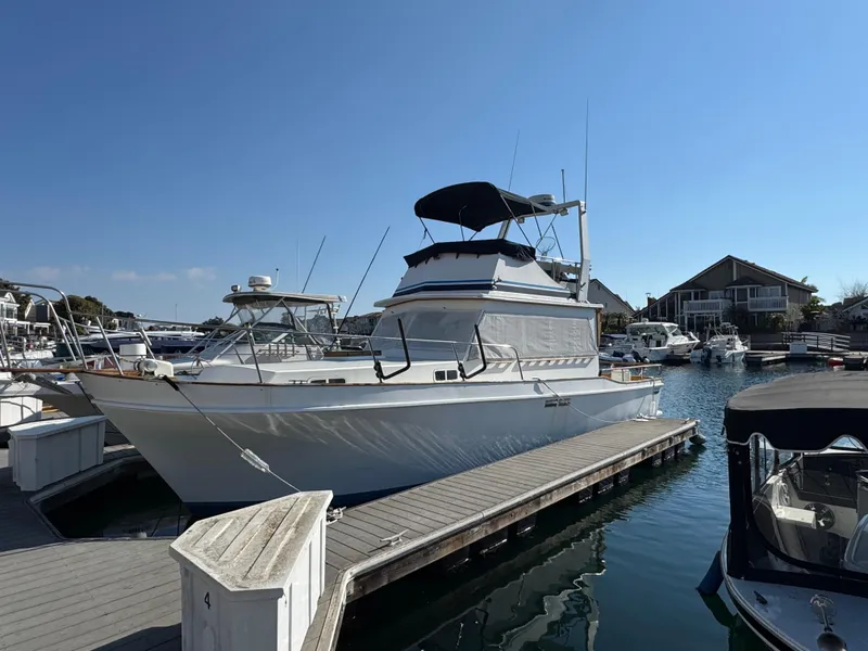 1979 Californian LRC Sedan Bridge docked at marina under clear blue sky.