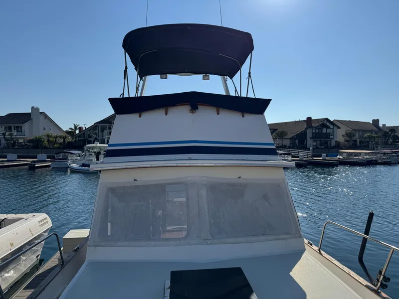 1979 Californian LRC Sedan Bridge docked at marina under clear blue sky.