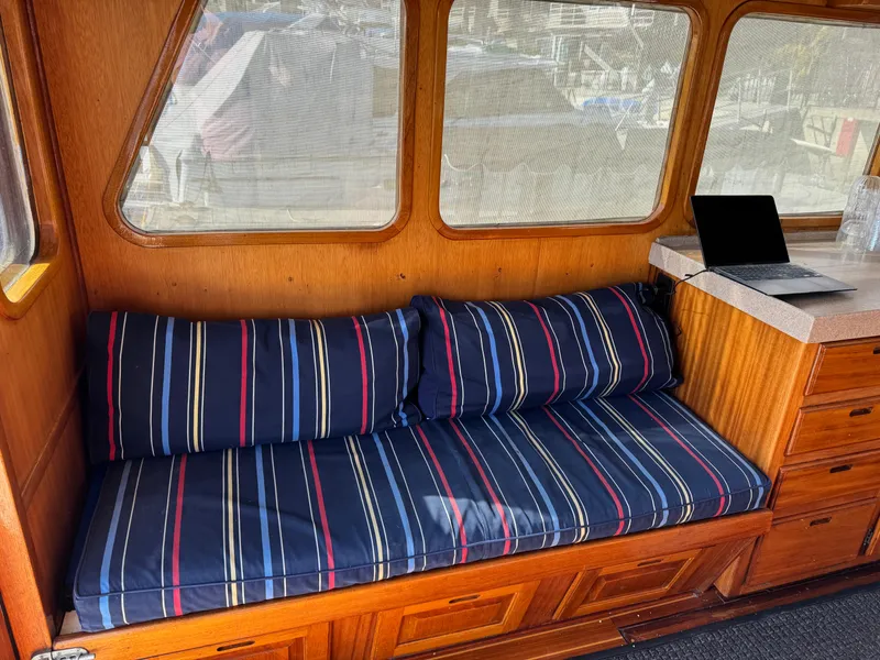 Interior of 1979 Californian LRC Sedan Bridge with striped cushions and laptop on counter.