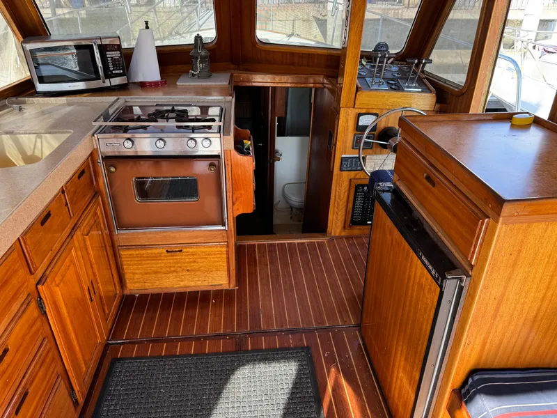 1979 Californian LRC Sedan Bridge interior with wood cabinetry, stove, and steering wheel.