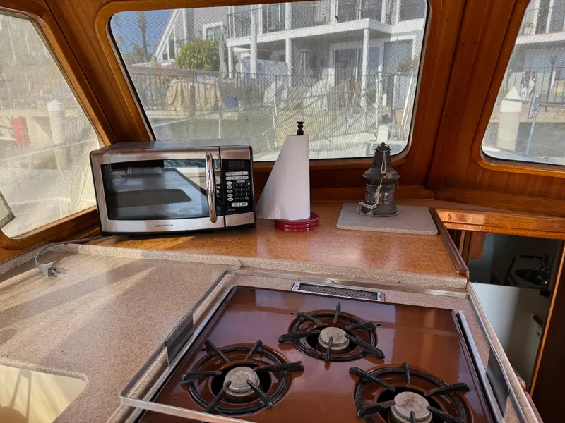 1979 Californian LRC Sedan Bridge kitchen with stove, microwave, and paper towel holder.