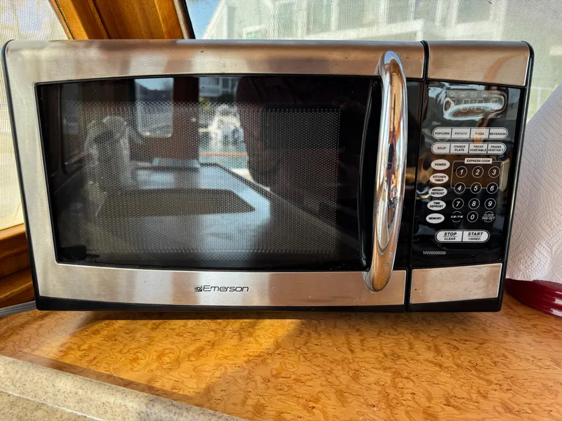 Microwave oven on a wooden countertop inside a 1979 Californian LRC Sedan Bridge.