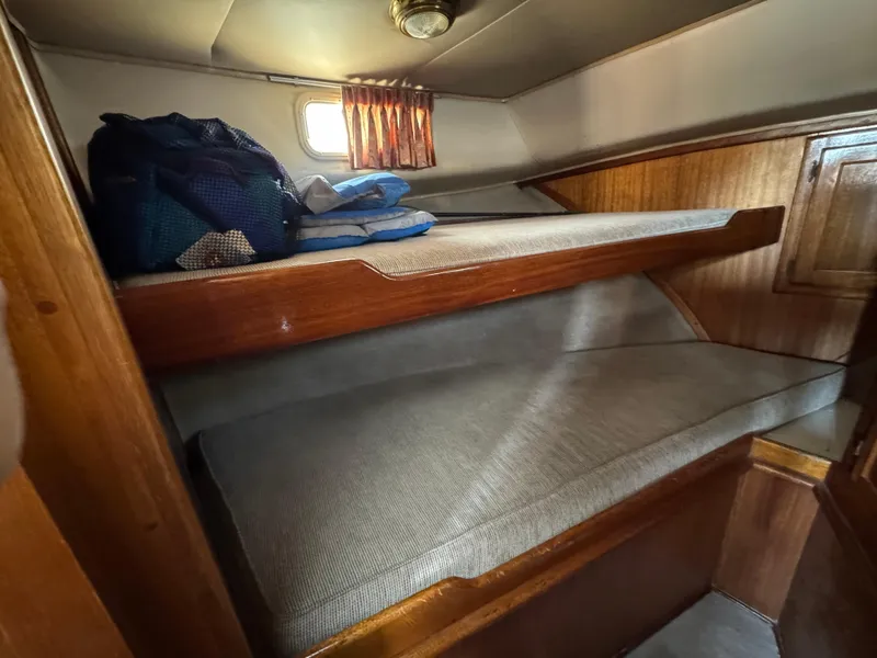 1979 Californian LRC Sedan Bridge cabin with wooden bunk beds and small window.
