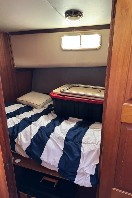 1979 Californian LRC Sedan Bridge cabin with striped bedding and storage container.