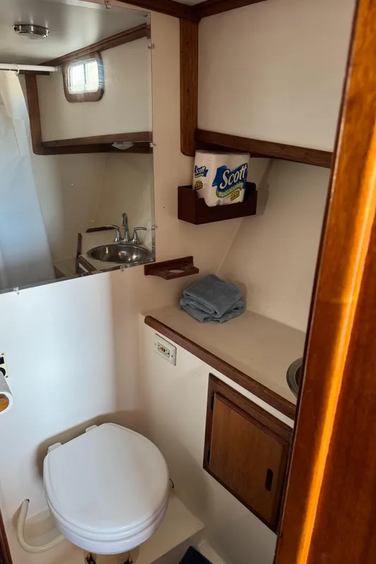 1979 Californian LRC Sedan Bridge bathroom with sink, toilet, and storage shelves.