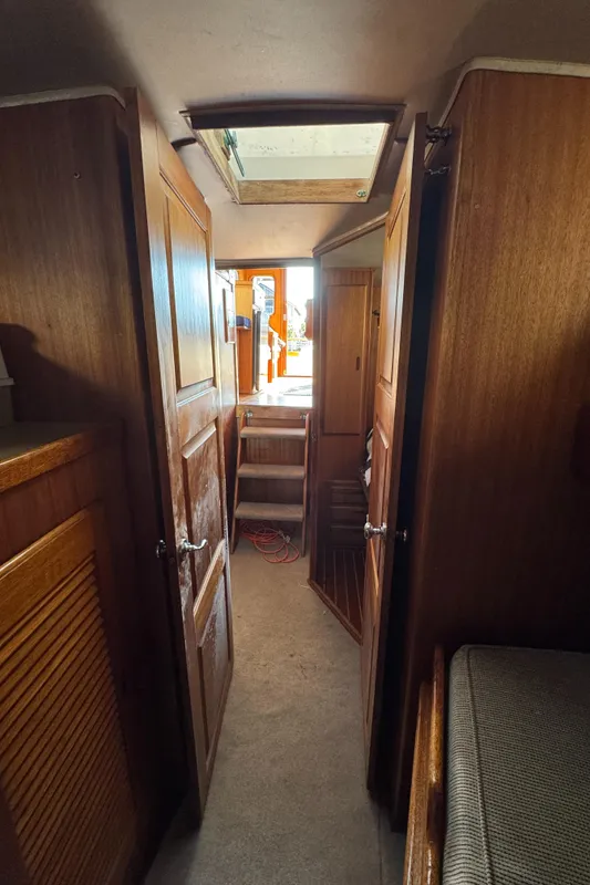 Interior of a 1979 Californian LRC Sedan Bridge, featuring wooden doors and a carpeted hallway.