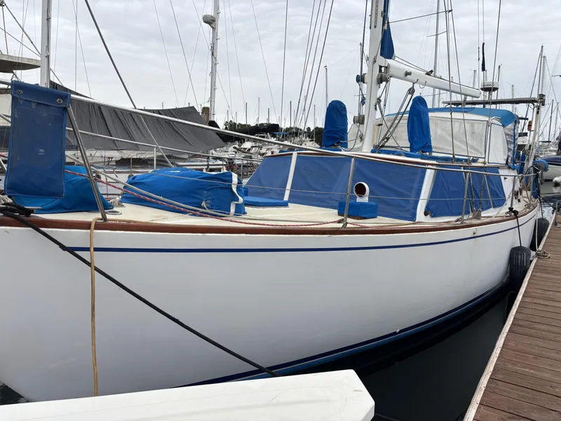 1973 CAL 246 sailboat docked at marina with blue covers and white hull.
