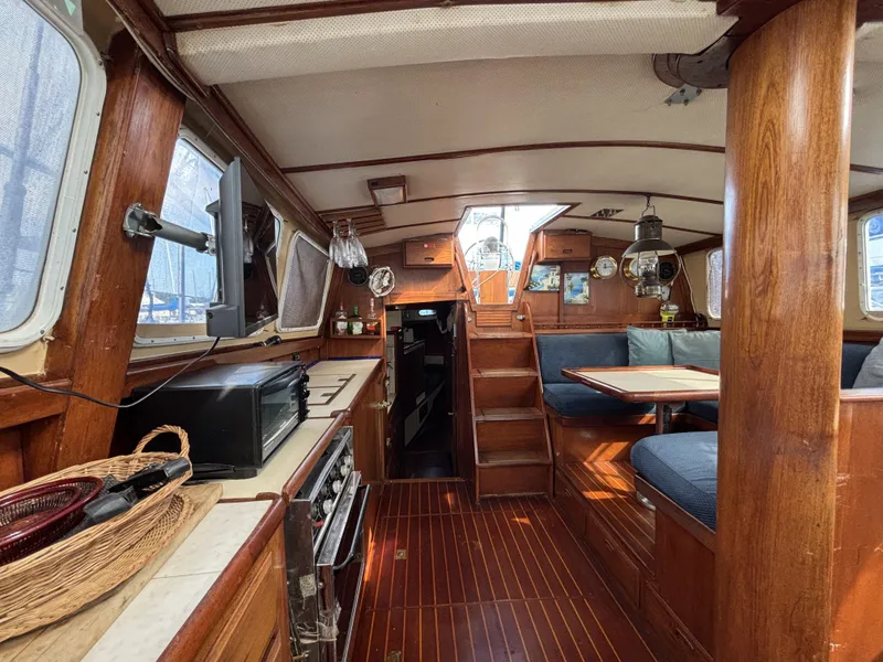 1973 CAL 246 sailboat interior with wood finish, dining area, and kitchen appliances.